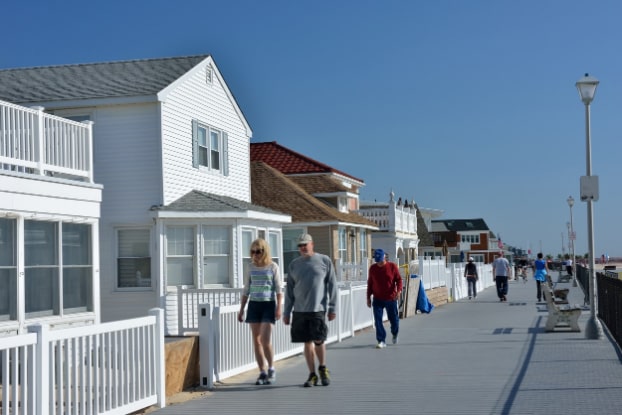 People Walking Along Boardwalk Past Beach Vacation Rental Houses on the East Coast
